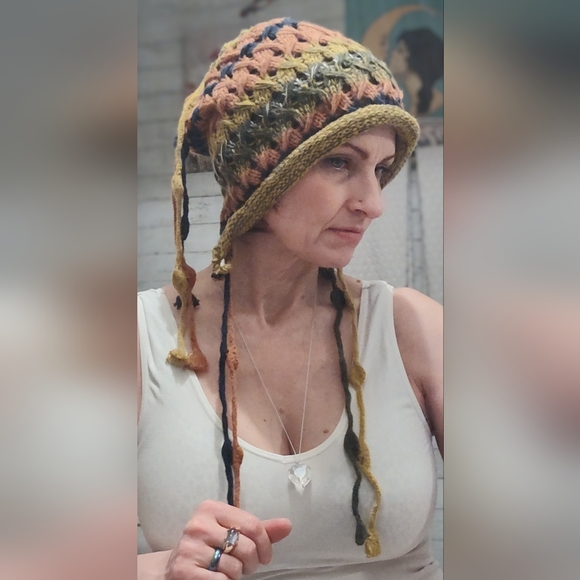 Accessories - hand-crocheted multicolor beanie with ear flaps and tassel details.